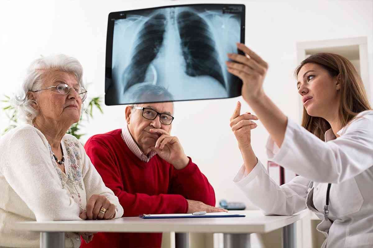 Läkare visar ett äldre par en bild på ett par lungor.